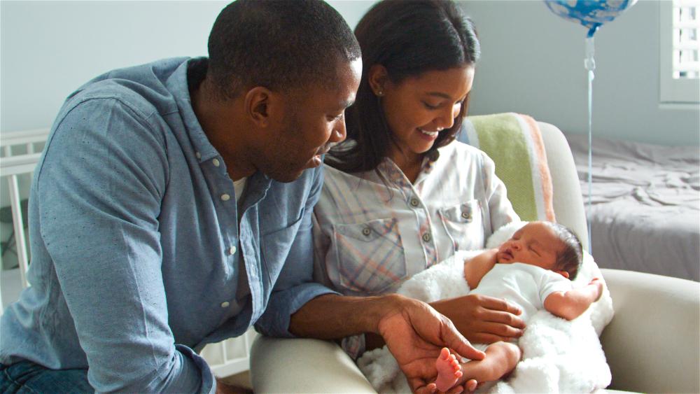 Couple looking at baby.