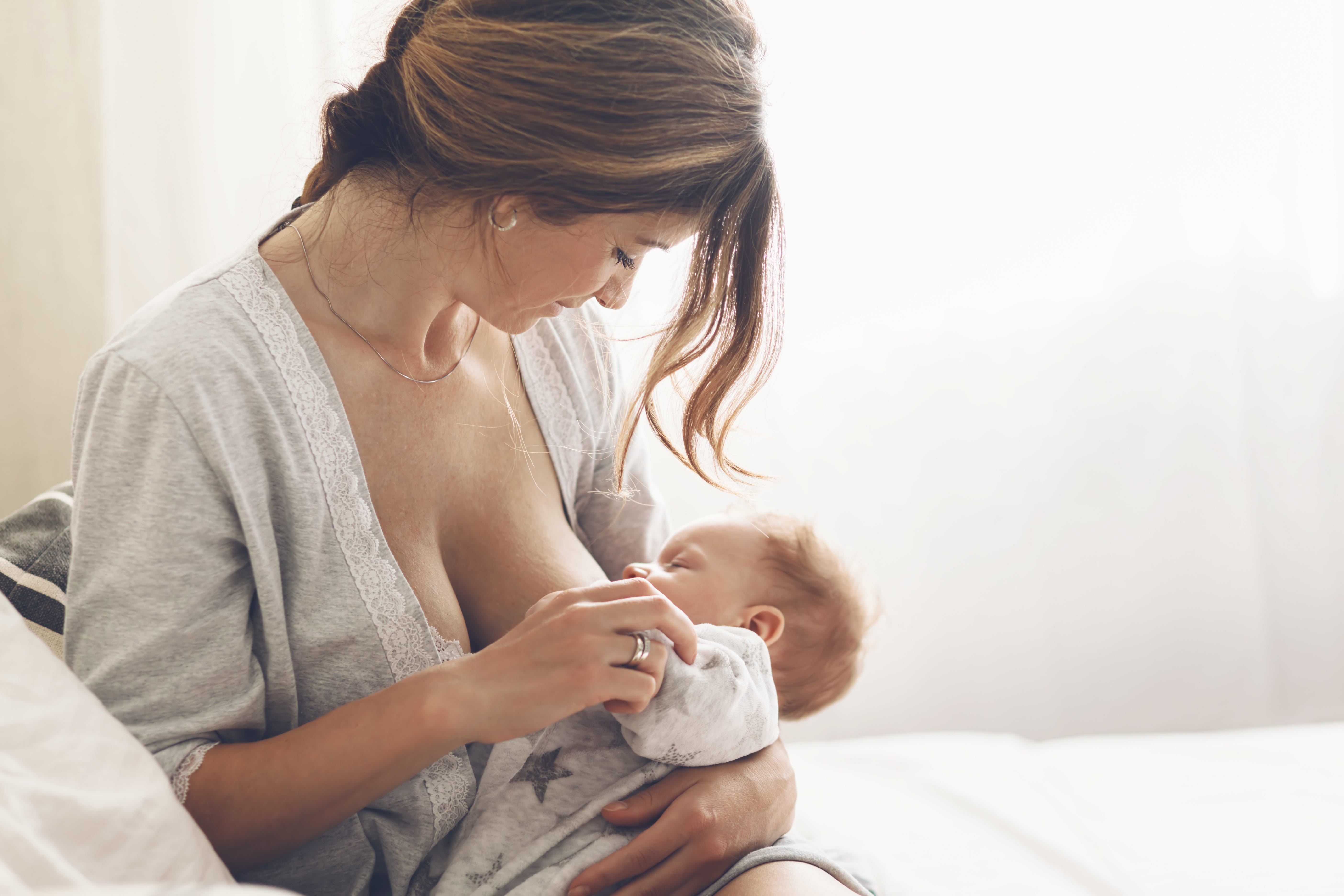 Mom holding baby and is breastfeeding baby