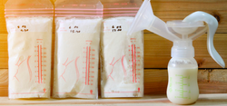 Milk storage bags lined up with a breast pump on side.