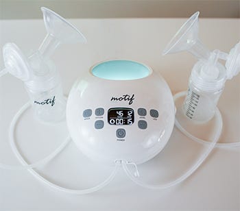 Motif dual breast pump with bottles and tubing on a white surface