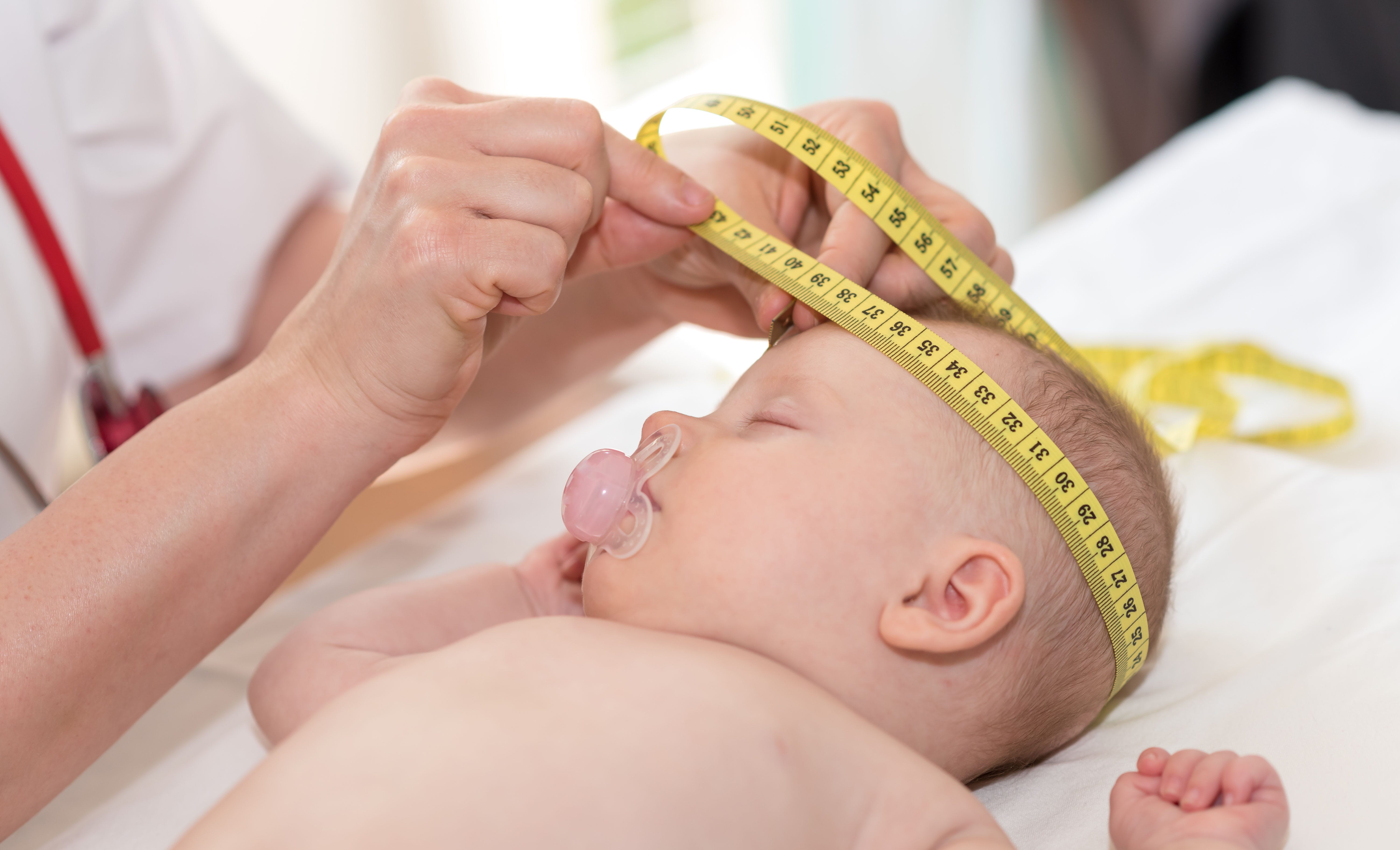 Doctor measuring baby head circumference. Pediatrician place