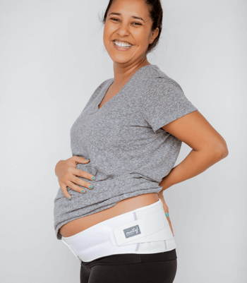 Pregnant woman smiling and wearing a Motif maternity support band