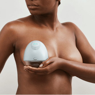 Woman holding an Elvie breast pump to her chest